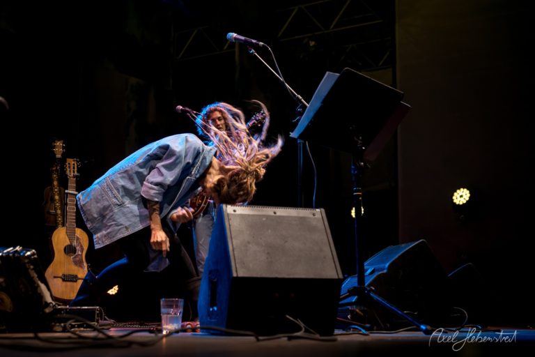 Zwei Musiker auf der Bühne, energetisch beim Spielen, umgeben von Instrumenten und Lichtern – © Axel Hebenstreit