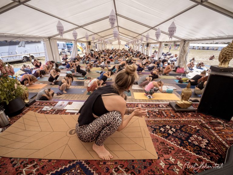 Yoga-Teilnehmerinnen praktizieren in einem festlichen Zelt während eines Festivals in Bayern. – © Axel Hebenstreit