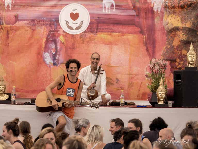 Zwei Musiker spielen live auf einer spirituellen Veranstaltung umgeben von einem begeisterten Publikum – © Axel Hebenstreit