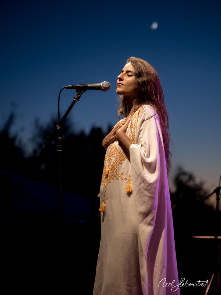 Eine Sängerin performt gefühlvoll auf einer Bühne bei Sonnenuntergang – © Axel Hebenstreit