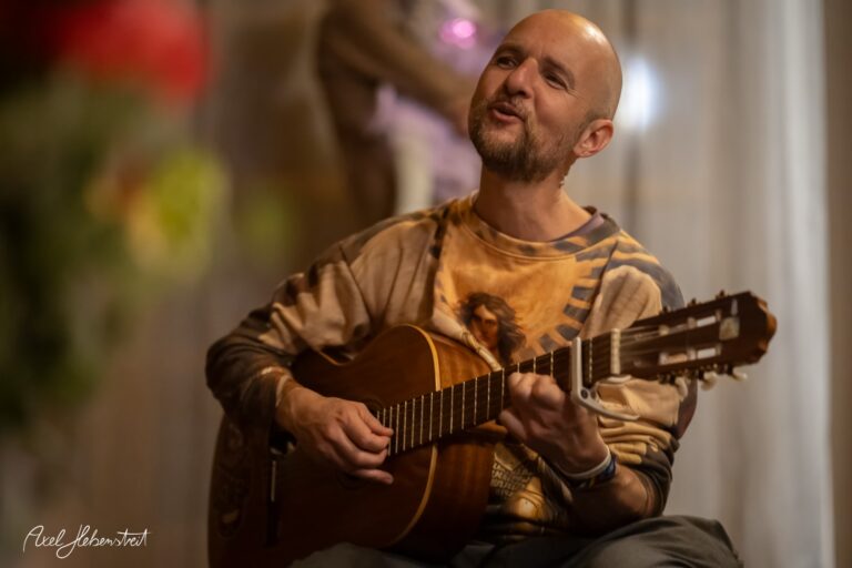 Musiker spielt konzentriert Gitarre bei stimmungsvollem Indoor-Auftritt