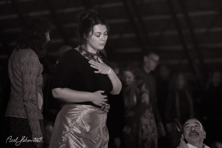 Eine nachdenkliche Frau in einer entspannenden Pose, umgeben von einer meditativen Festivalatmosphäre – © Axel Hebenstreit