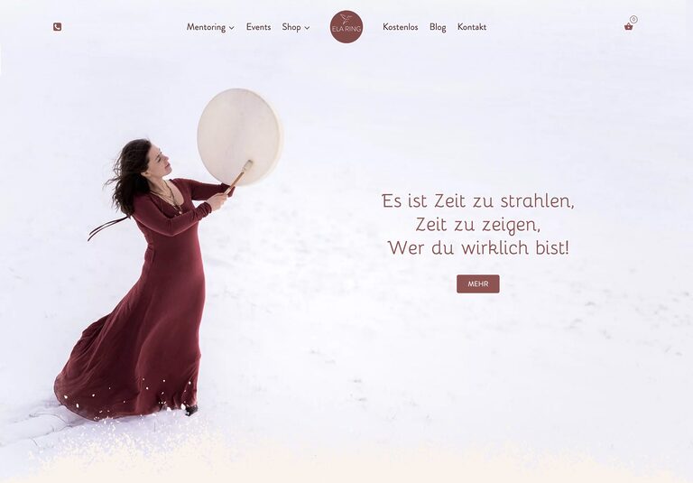 Frau in rotem Kleid spielt auf Trommel im Schnee und strahlt Lebensfreude aus – © Axel Hebenstreit