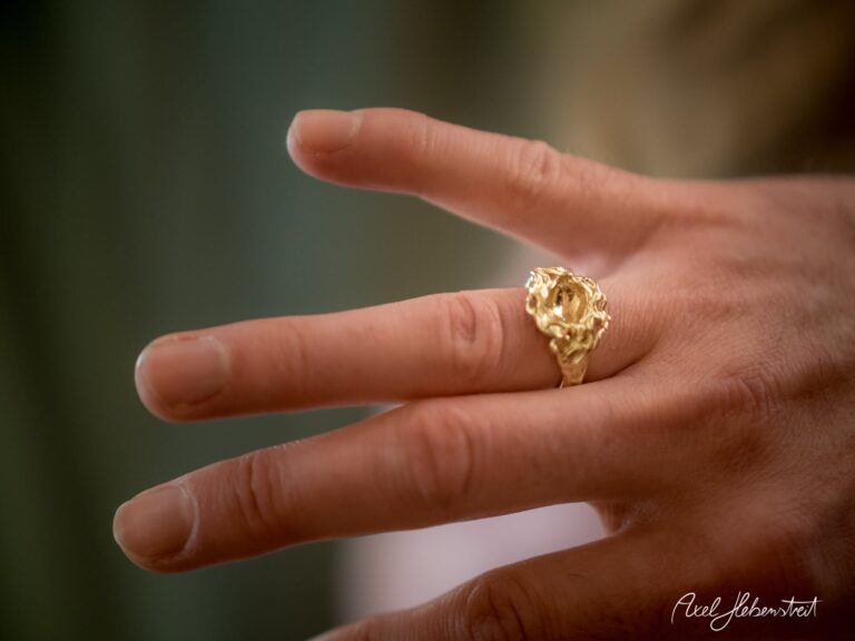 Eleganter goldener Ring auf einem Finger präsentiert, zeigt zarte Details und eine spezielle Form – © Axel Hebenstreit.