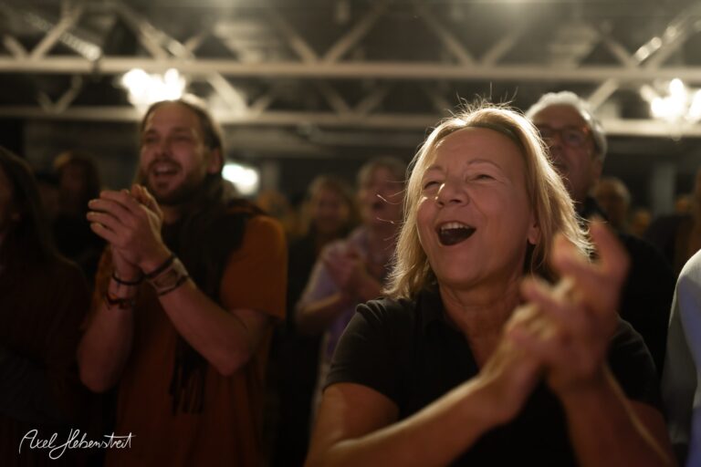 Begeisterte Menschen applaudieren euphorisch in einem Konzertsaal – © Axel Hebenstreit